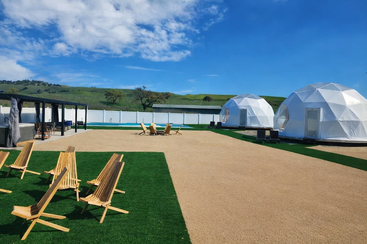 Lounge chairs on the lawn facing the geodesic domes and rolling hills