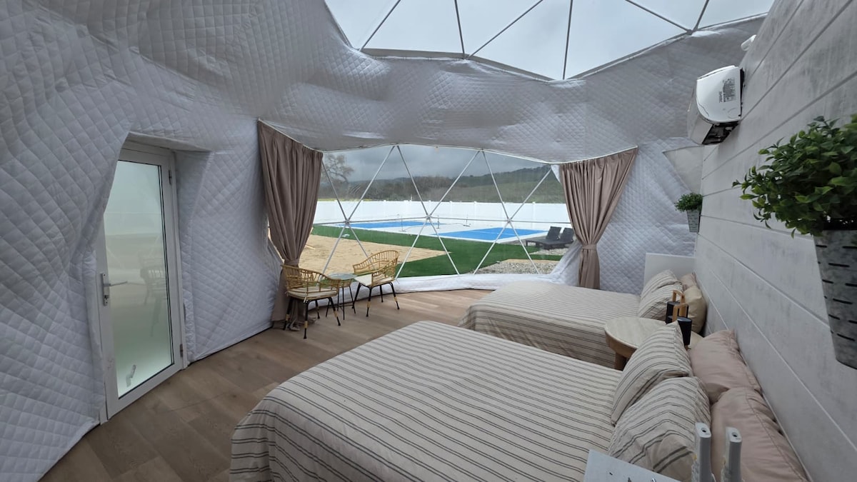 Dome bedroom with striped linens and pool view
