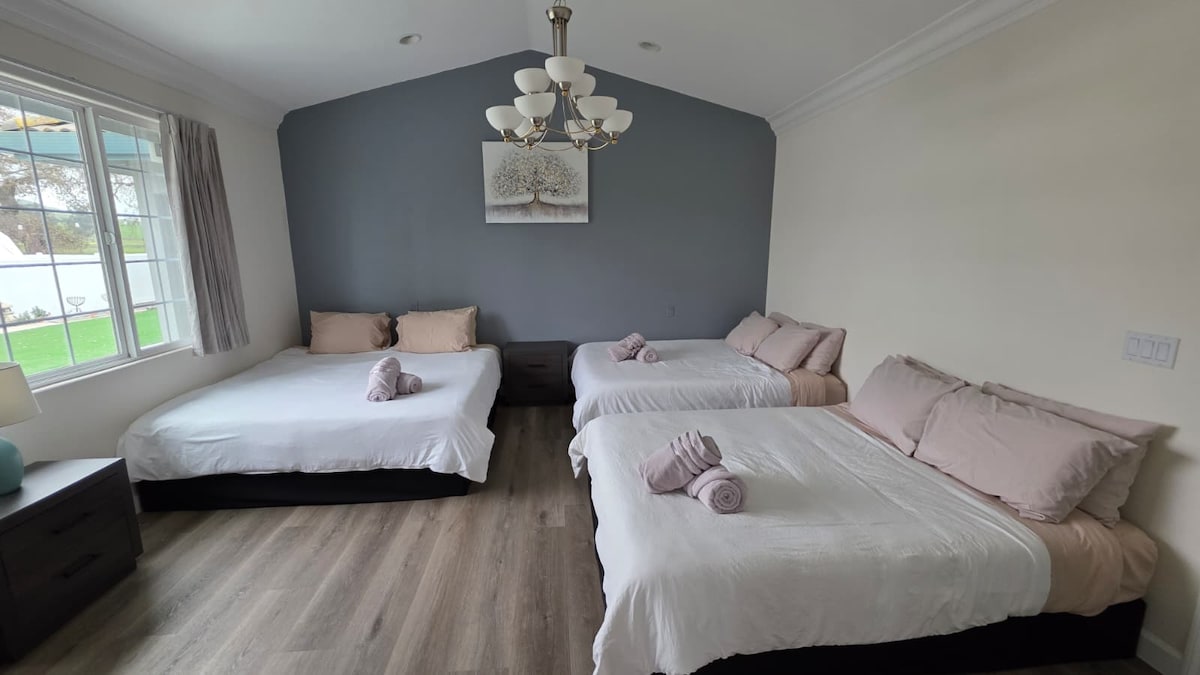 Bedroom with three beds and a chandelier