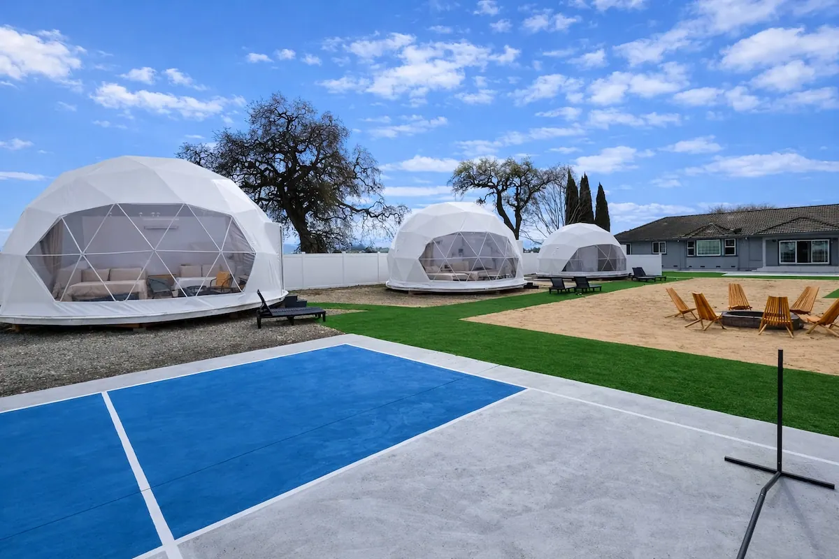 Three geodesic domes with fire pit and sport court