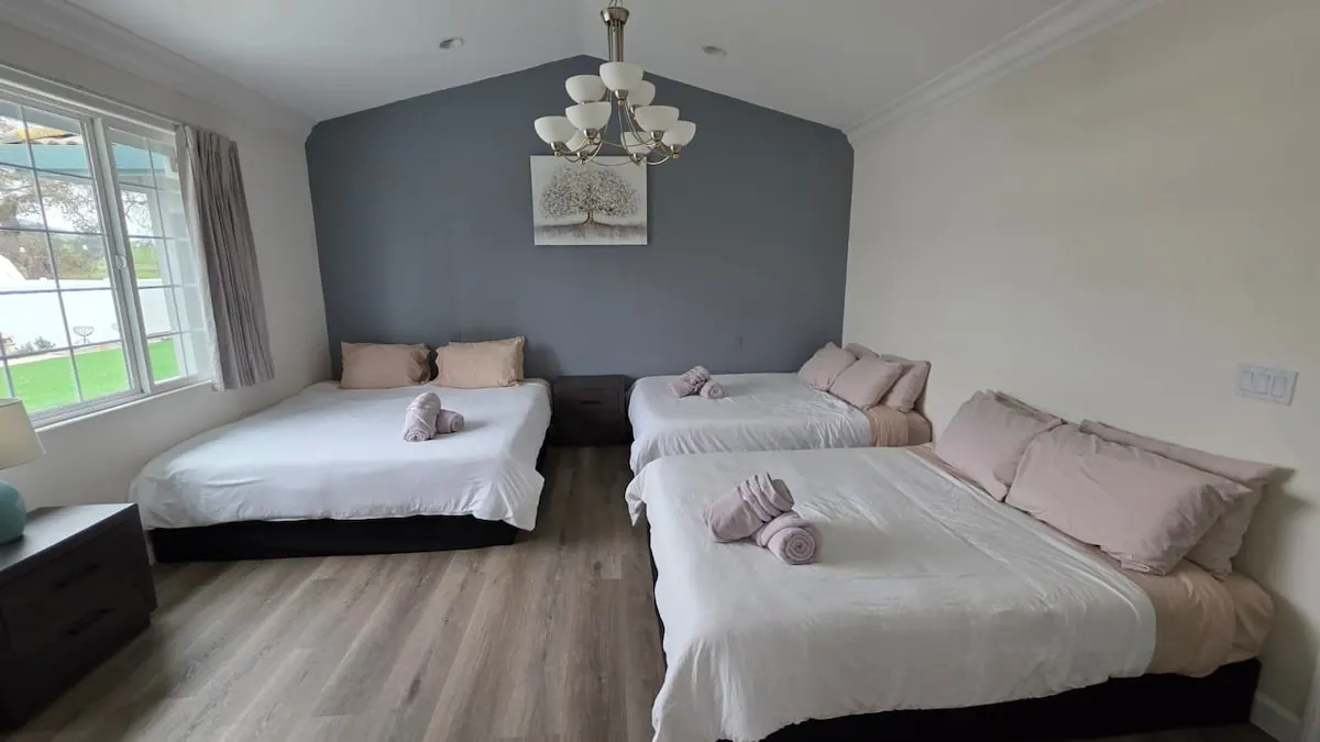 Bedroom with three beds and a chandelier
